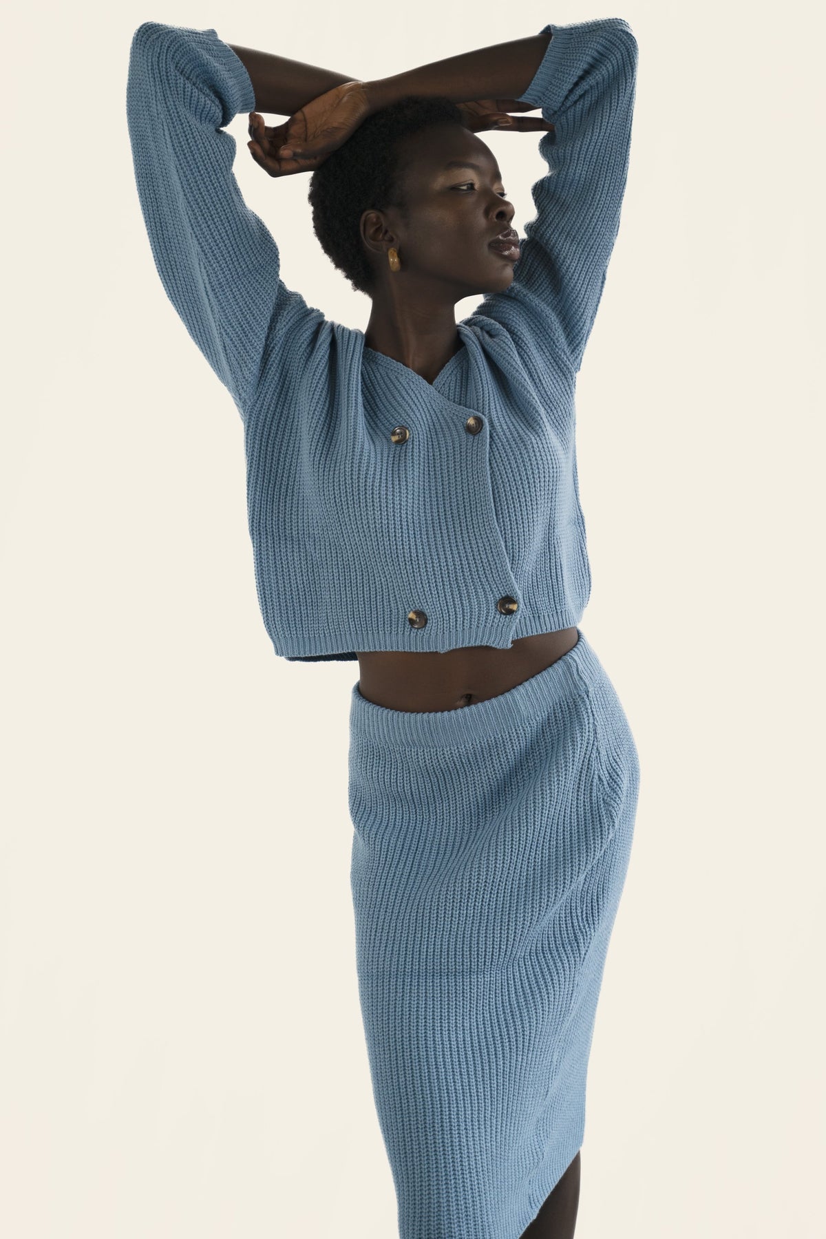Model wears blue rib-knit matching cardigan and skirt set. Front facing,