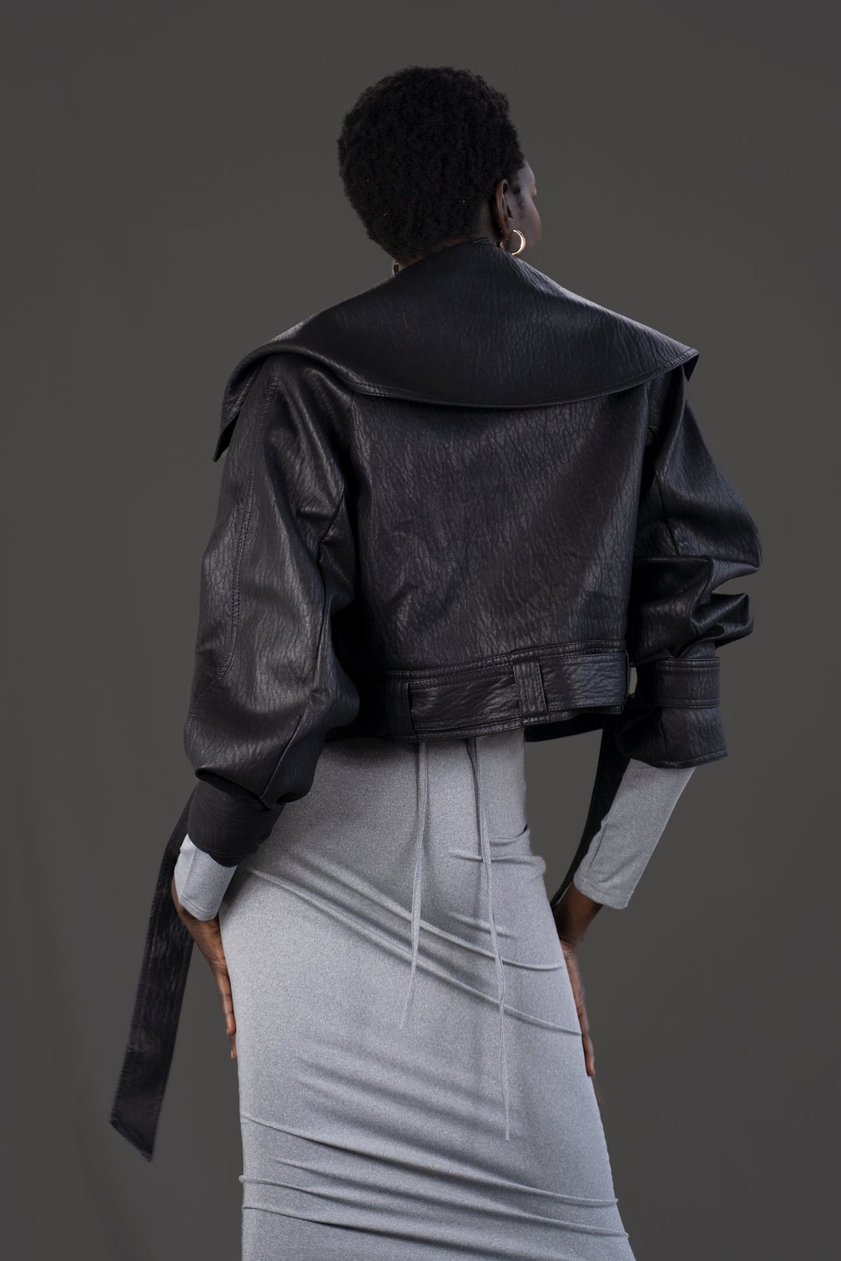 Model wearing the asym vegan leather oversized jacket. Size medium  Back side.