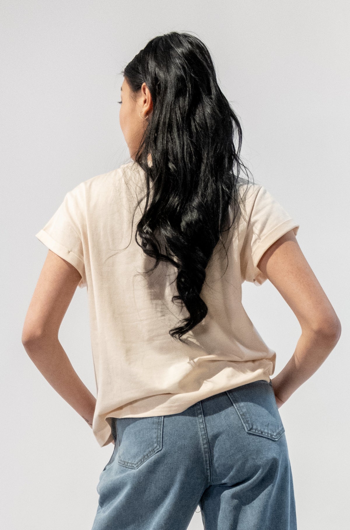 Model wearing a Floral Gal Graphic T-Shirt with vibrant floral design. Back side.