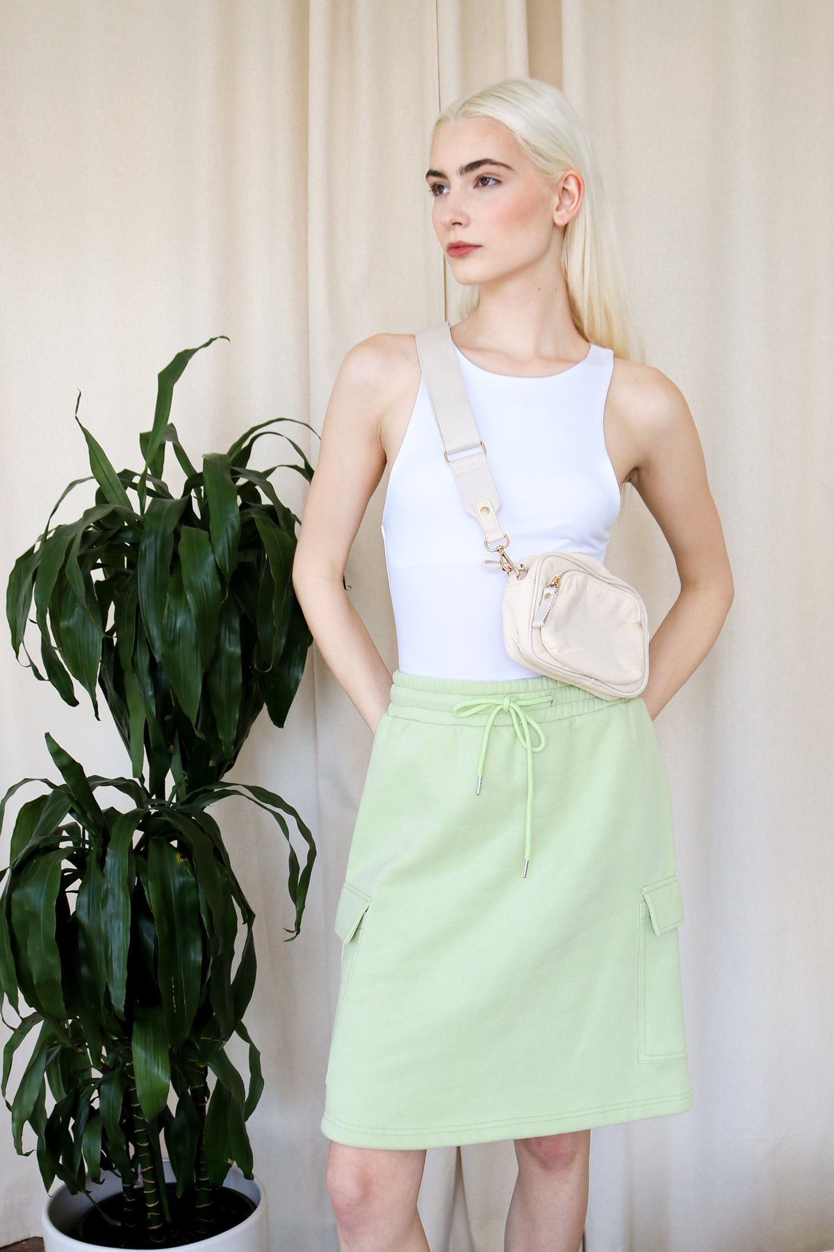 Model wears cargo midi skirt in bright green against a neutral backdrop. Front-facing.