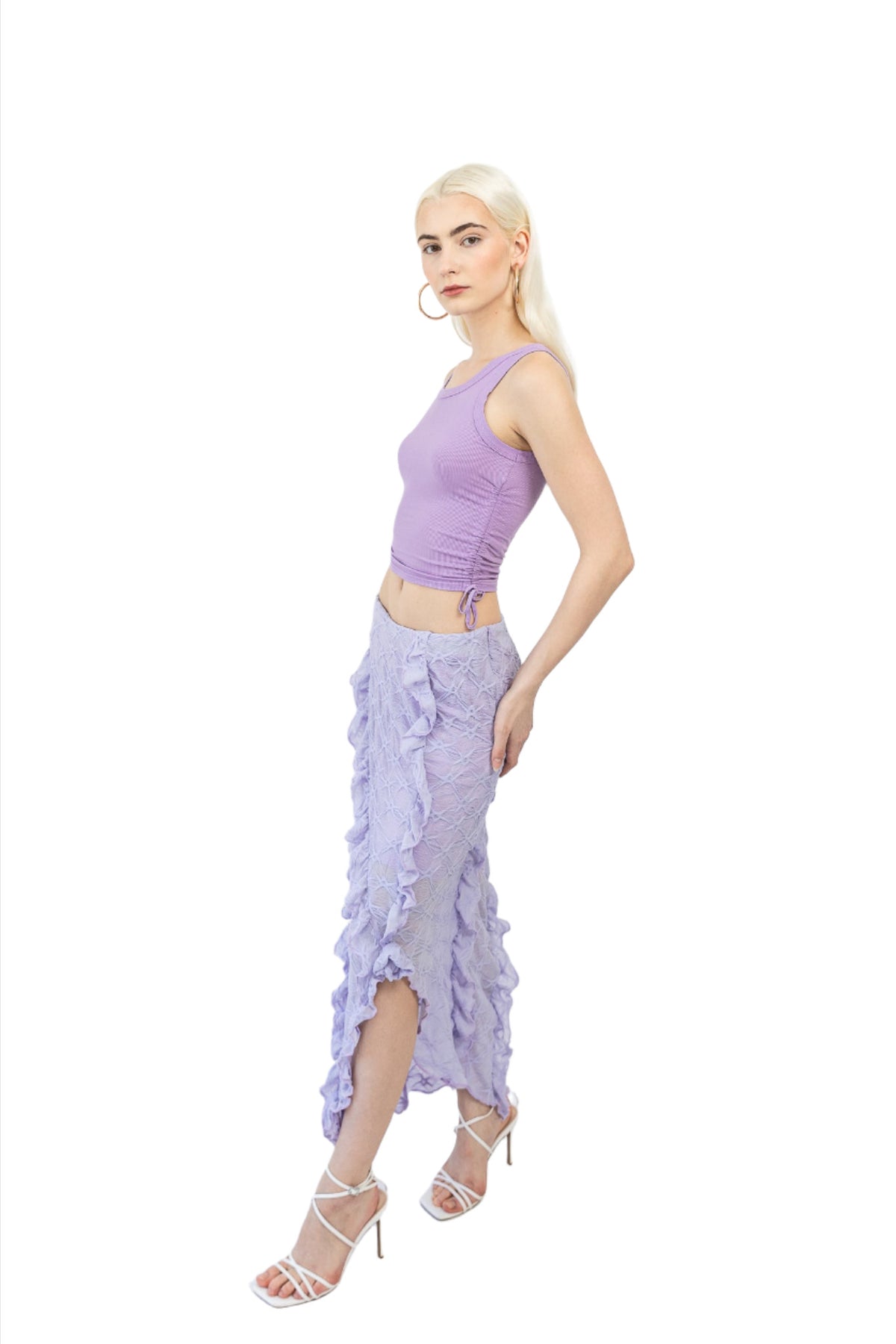 Model wears Mermaid Maxi Skirt in Lilac. Left side facing. Styled with a purple top.