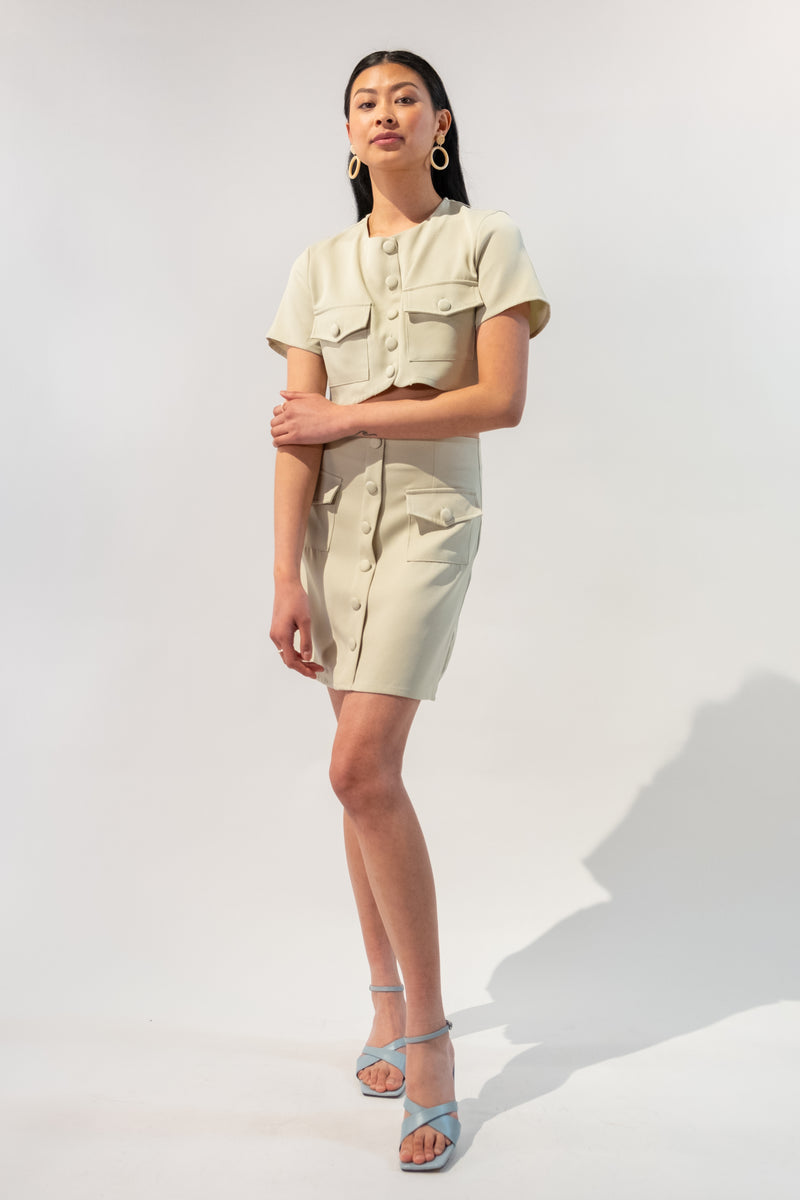 Model wearing a chic short sleeve button-up crop top and button skirt set in beige