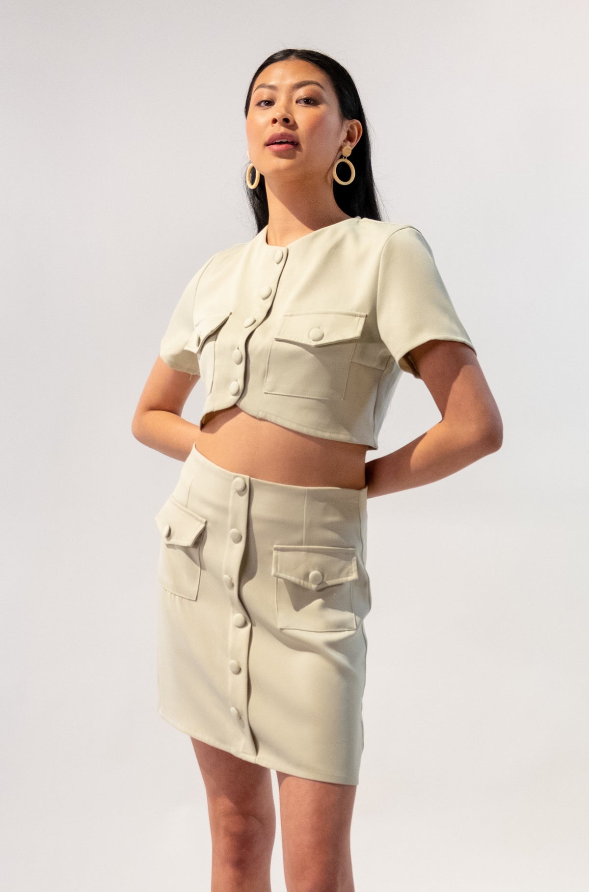 Model wearing a chic short sleeve button-up crop top and button skirt set in beige