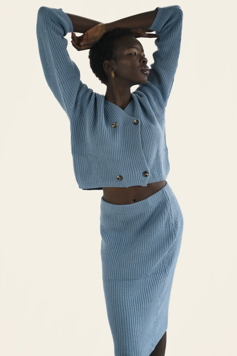 Model wears blue rib-knit matching cardigan and skirt set. Front facing, 