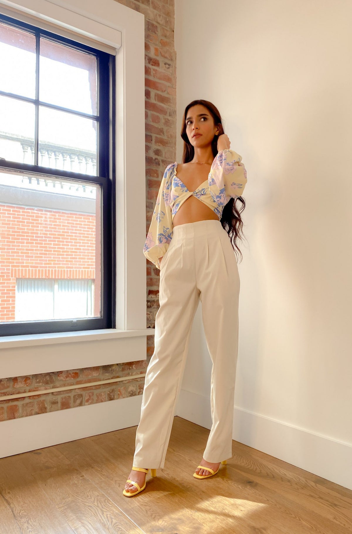 Model standing in a bright room wearing our High Waist Wide Leg Pants. 